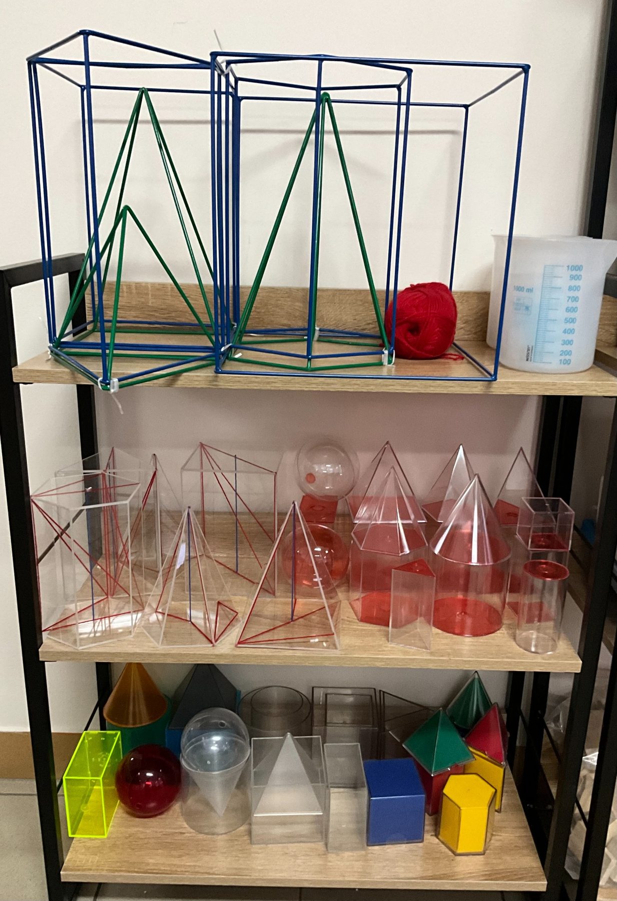 Półka z modelami brył geometrycznych i pomocami dydaktycznymi